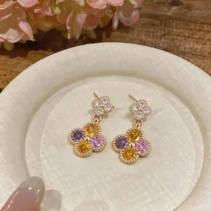 Makro-Detail von eleganten bunten Blumen-Zirkon-Ohrsteckern mit luxuriöser Goldbeschichtung