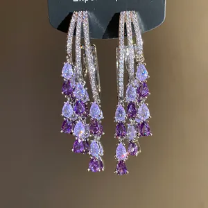 Close-up of elegant purple water-drop tassel earrings with shimmering cubic zirconia.