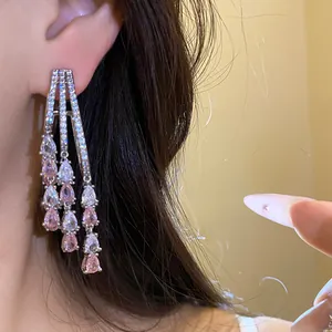 Close-up detail of 18k gold plated tassel earrings featuring pink waterdrop zircon gems