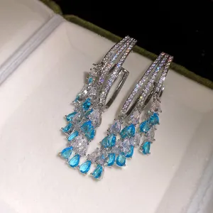 Macro view of blue and clear pear-cut zircon stones on elegant drop earrings