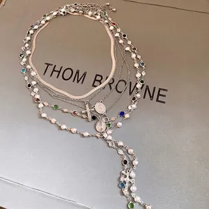 Elegant multi-layer necklace with pearls, rhinestones, and silver cross pendant
