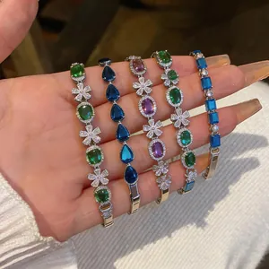 Detailed close-up of sparkling colorful cubic zirconia flower bracelets held in hand