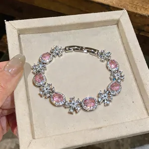 Close-up of elegant floral bracelet with sparkling pink oval zircons in silver finish