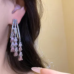 Detailed close-up of sparkling pink and white zircon water-drop tassel earrings on ear.