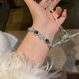Detailed macro shot of an elegant silver flower bracelet with green zircon stones.