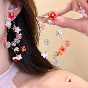 Detailed view of long resin flower tassel earrings on ear for a sweet vacation look