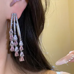 Detail of 18k gold plated tassel earrings with pink and white pear-cut cubic zirconia stones.