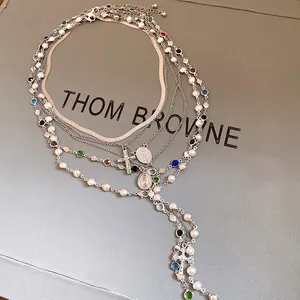 Detail view of multi-layered silver necklace with pearls and cross pendant