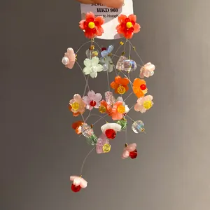 Detailed view of colorful resin flower tassel earrings with clear beads and silver needles