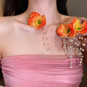 Detail of elegant orange fabric poppy flower and pearl tassel necklace earring set
