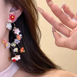 Close-up of sweet resin flower tassel earrings with silver needles on model