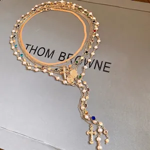 Detailed macro view of a multi-layer gold necklace with pearls and cross pendants