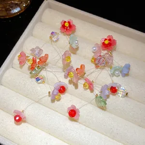 Close-up of handmade resin flower tassel earrings with colorful crystal beads and pearls