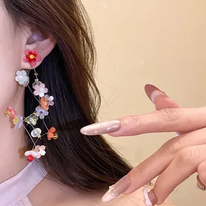 Close-up detail of sweet resin flower tassel earrings with colorful holiday floral elements