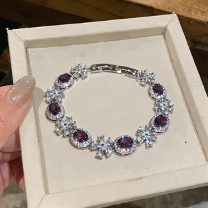 Close-up of elegant silver bracelet with purple oval stones and zircon flowers