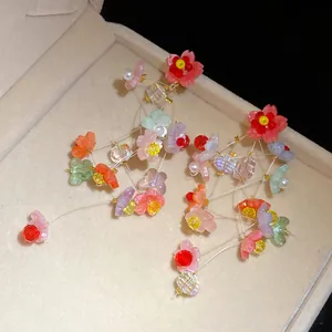 Macro view of sweet resin flower tassel earrings with silver needles for a chic vacation look.