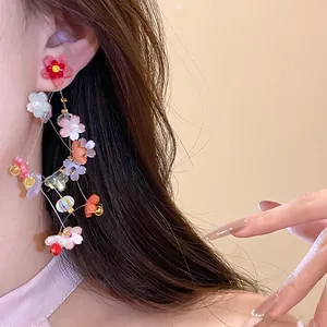 Detailed view of colorful resin flower tassel earrings with silver needles on model