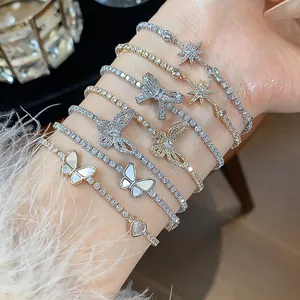 Dettaglio di vari braccialetti placcati in oro 18k con zirconi, ciondoli farfalla e stella