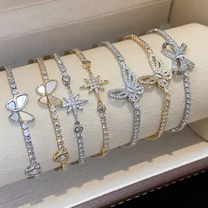 Primo piano di eleganti bracciali placcati in oro 18k con motivi a farfalla e stella