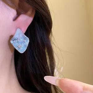 Elegant silver rhombus stud earrings with a unique textured finish and zircon accents.
