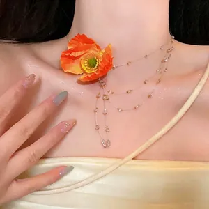 Detailed view of the elegant orange fabric flower necklace with crystal bead tassels