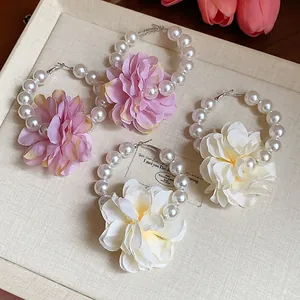 Primo piano dettagliato di orecchini a cerchio con fiori in tessuto e perle eleganti