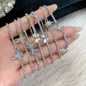 Dettaglio di bracciali a farfalla e stella placcati oro 18k con zirconi scintillanti.