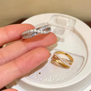 Detailed macro view of gold and silver crisscross rings with pearls and zircons