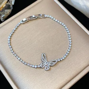 Dettaglio ravvicinato di un bracciale a farfalla con zirconi su un'elegante scatola regalo