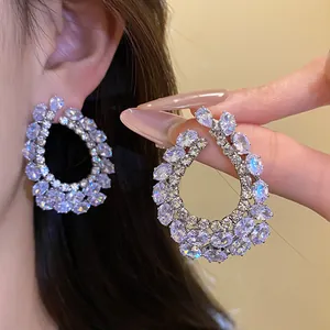 Gedetailleerde weergave van luxe druppeloorbellen met fonkelende marquise-zirkonen en zilver.