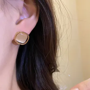 Close-up detail of a vintage French style cat eye stone ear stud worn on a model ear