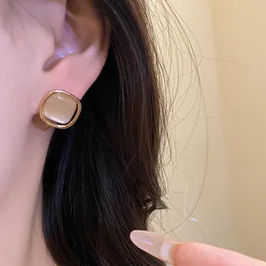Close-up of retro French style square cat's eye stone stud earring with gold-tone frame
