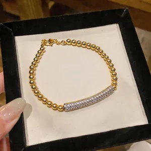 Elegant gold beaded bracelet with zircon pavé bar centerpiece in a black velvet box