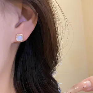Elegant close-up shot of French vintage cat-eye stone stud earrings worn on a model's ear