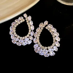Close-up van elegante druppeloorbellen met glinsterende marquise en ovale zirkoon.