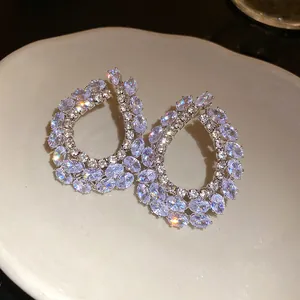 Detailweergave van geometrische druppeloorbellen met fonkelende zirkoniasteen