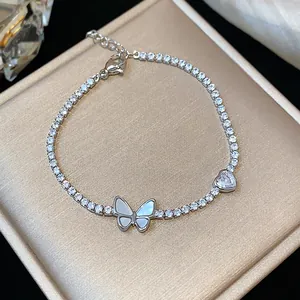 Primo piano di un bracciale in zircone scintillante con farfalla in madreperla e cuore