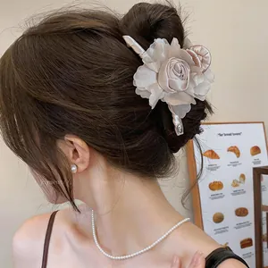 Elegante molletta per capelli a fiore in raso champagne per acconciature chic da donna.