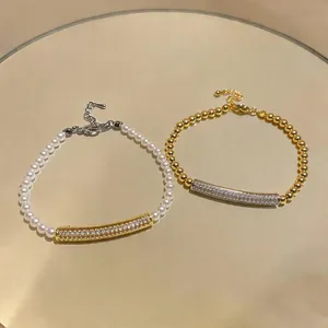 Detail view of two elegant zircon and pearl bracelets on a reflective surface