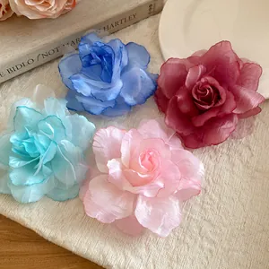 Close-up view of four elegant mesh fabric flower hair clips in various spring colors
