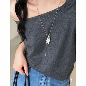 Close-up of an adjustable silver-tone necklace featuring a white pearl grape cluster pendant