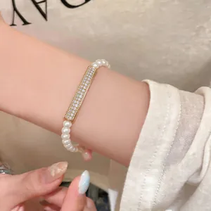 Detailed view of an elegant pearl bracelet featuring a gold bar paved with zirconias