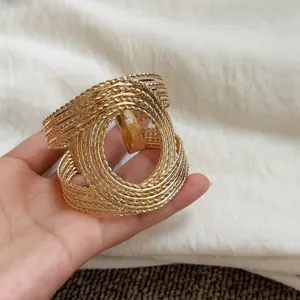 Detailed view of a vintage golden cuff bracelet with intricate woven rope texture