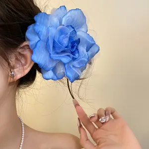 Detailed close-up showing an elegant blue mesh rose flower hair clip on a model