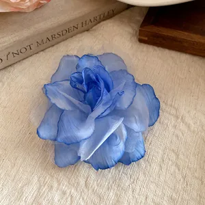 Detailed view of a blue gradient fabric mesh flower hair clip with layered petals.