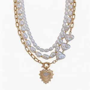 Collar multicapa de perlas barrocas con un colgante de corazón dorado y cristales
