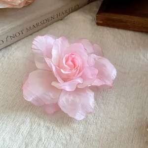 Detail showing the layered pink mesh petals of a handmade fabric flower hair clip.