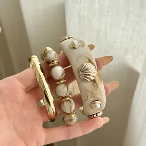 Vintage gold-tone stacked bracelet set with marbled beads and chic gold shell detail