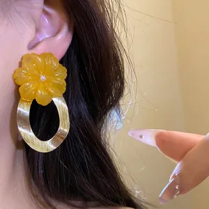 Eleganti orecchini a fiore in resina gialla con pendente a cerchio ovale dorato