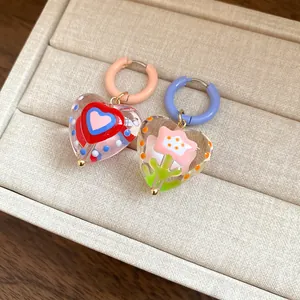 Close-up of dopamine style heart earrings with internal flower and heart patterns.
